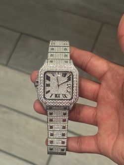 This Cartier Santos watch is a custom "iced out" model featuring a fully diamond-pave bezel, case, and bracelet.