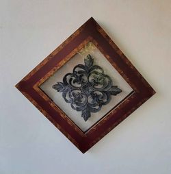 Set of two wall art objects, heavy metal decorative with a wooden frame, similar to vintage brass wall art styles from the 1990s. M:23 1/2" x 23 1/2"