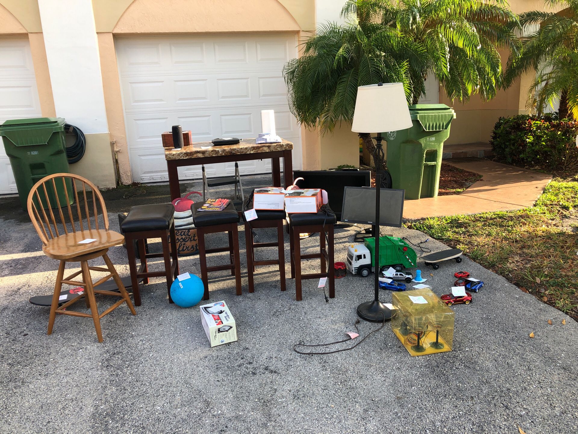Yard Sale items table, jbl speaker, stools, tv, sign, toys, humidor, monitor
