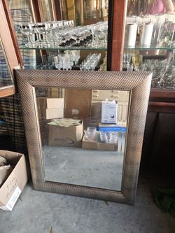  decorative wall mirror featuring a champagne-colored polystyrene frame with a repeating textured honeycomb pattern. 