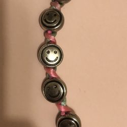 Adorable 7.5” long silver happy faces and pink ribbon necklace. Never worn!