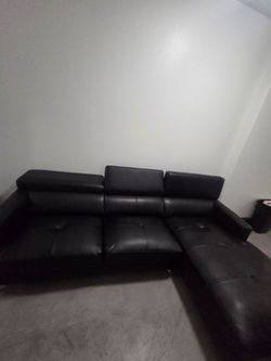 Black leather sectional sofa left-facing chaise, tufted seat cushions