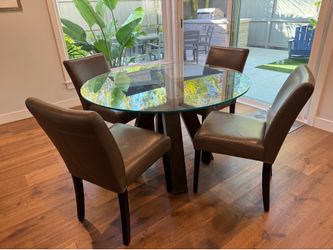 Pottery Barn black pedestal 48” glass round dining table with 4 gray leather chairs