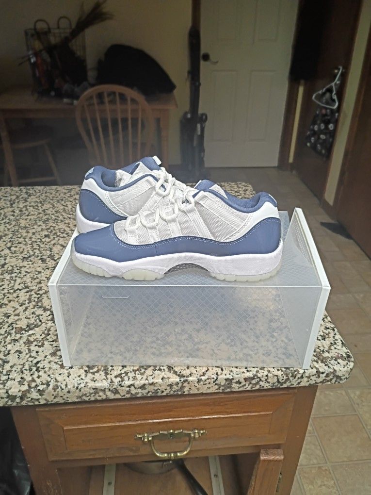 Jordan 11 Retro Low in the "Diffused Blue" colorway, featuring a white ballistic mesh upper with a glossy patent leather overlay. 