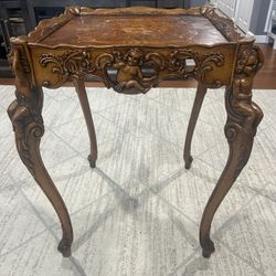 Antique heavily carved cherub wood table