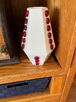 White ceramic candle holder/flower vase with red glass accents.