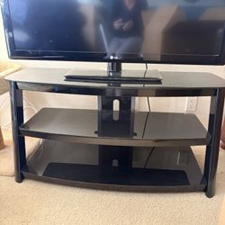 “MOVING SALE”.  Black Glass and metal TV stand