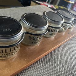 Bulleit Frontier Whiskey branded jars on a wooden tray.