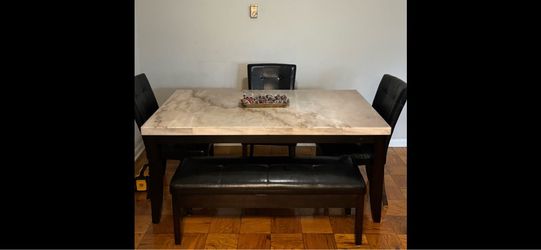 Marble table with three chairs and seating storage