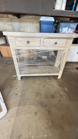 Small whitewashed wood cabinet with 2 drawers and open shelf