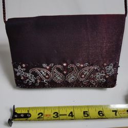 1960  dark   Purple burgundy evening bag made of a shimmery fabric. 

