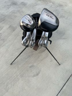 Full set of golf clubs w balls and tees.