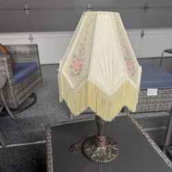 Victorian-style table lamp with fringe shade.