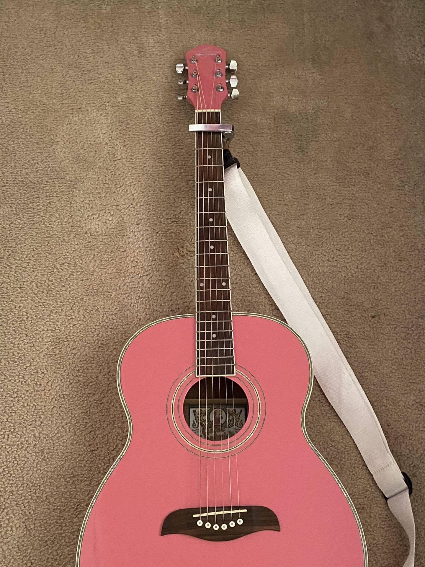 New / Never used Oscar Schmidt pink guitar with capo and strap