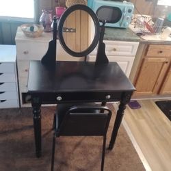 Black Vanity Table With Chair And A TV Stand With Shelves In It