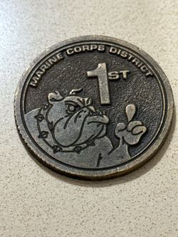 bronze-colored Marine Corps District 1st challenge coin featuring a bulldog mascot.