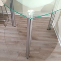 Beautiful glass dinning table with 3 pearl white and stainless chairs.