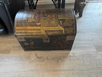 Vintage Chinese black lacquered storage trunk with hand-painted gold scenes.