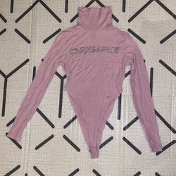 Pink long-sleeve turtleneck bodysuit with 'Desire' rhinestone text.