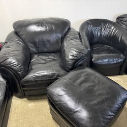 Two black leather chairs and one ottoman