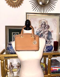 The bag is a New Recruits Dome Satchel model by Anne Klein in a light brown tone with top handles and a distinctive gold pendant with the logo.