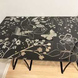 IKEA black and clear glass desk top with two black metal base.