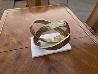 modern table sculpture by Benzara featuring intertwined ring loops in a bright gold finish.The decorative item is crafted from aluminum and rests on a