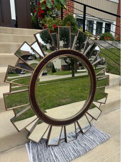 Home Goods contemporary decorative sunburst wall mirror featuring a dark brown frame.