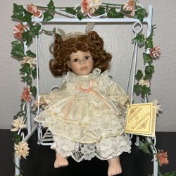Leonardo collection porcelain doll on a swing With Certificate Of Authenticity