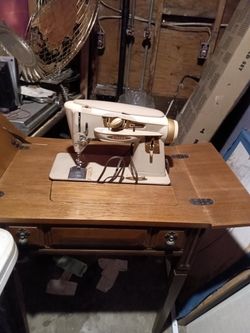 a vintage Singer Slant-O-Matic "Rocketeer" Model 500A sewing machine, housed inside a matching wooden sewing cabinet table