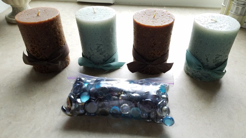 4 pillar candles and decorative glass pebbles