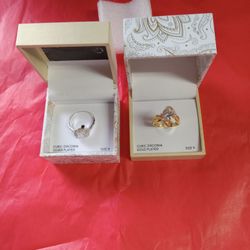 TWO CUBIC ZIRCONIA RINGS SIZE 9A GOLD PLATED AND SIVER PLATED RING IN A GIFT BOX. 