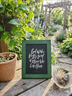 Green Framed piece of Christian wall art featuring the Bible verse Romans 8:28