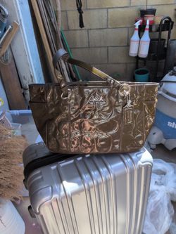 Coach F17729 embossed patent leather shoulder bag featuring silver accents.