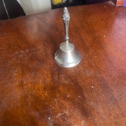 The object in the image is a sterling silver table or dinner bell. These bells were historically used to summon servants or to call a family to a meal