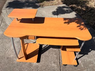 This is a wood-grain finish computer desk with a pull-out keyboard tray and an upper monitor/printer shelf.