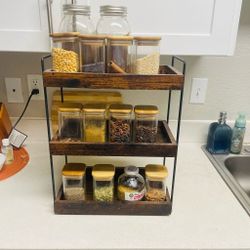 Three Tier Rack With Empty Spice Boxes And Kitchen Spatulas