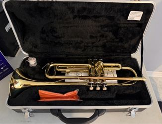 gold-colored Bb trumpet with a lacquer finish, housed in a hardshell case.