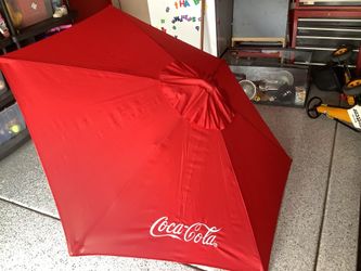 Coca Cola fabric with garden umbrella approximately 82” across never used.  Embroidered letters with carry bag, original tags beautiful bamboo like po