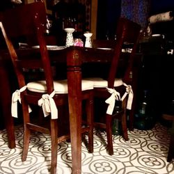 Tall, high back chairs and table with cushions