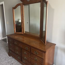 Vintage Wooden Bedroom Set: Dresser with Mirror, Four Poster Bed, and Nightstand.