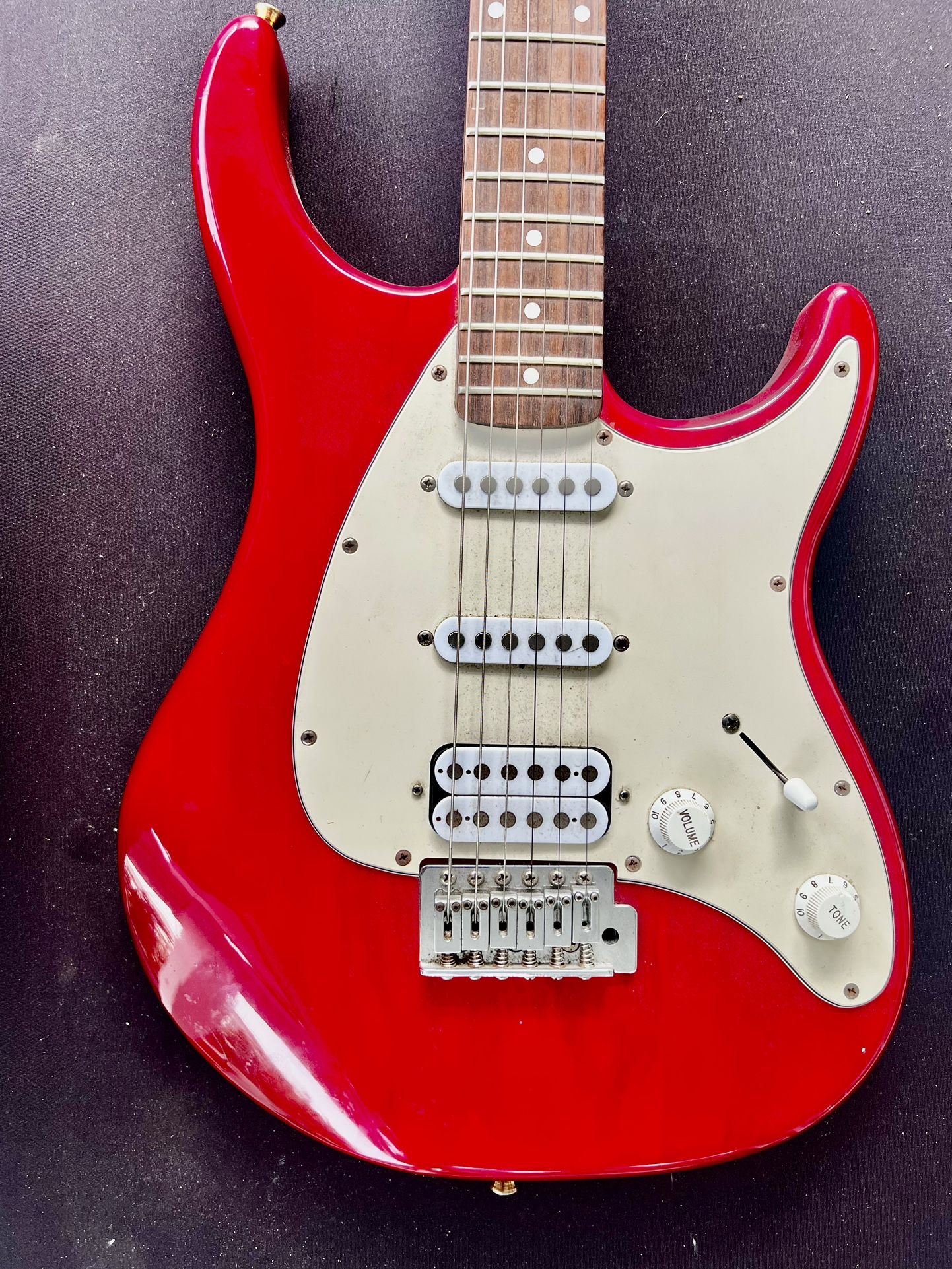 The 1990s Peavey Raptor Plus EXP Electric Guitar is a vintage right-handed electric guitar with a solid red body, featuring a maple neck and rosewood
