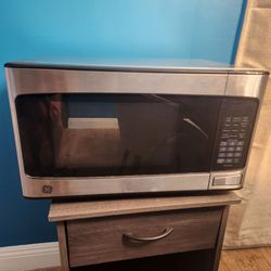GE 1.1 cu. ft. 950-Watt Countertop Microwave in stainless steel, featuring a sleek digital control panel and push-button door release