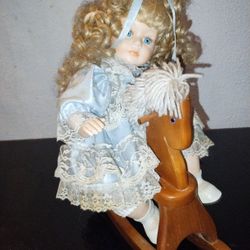 Porcelain Doll On A Wooden Horse