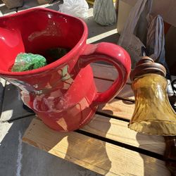 The red item is a Longaberger Woven Traditions pottery mug, likely in the "Tomato" or "Paprika" color. The pottery is known for its durability