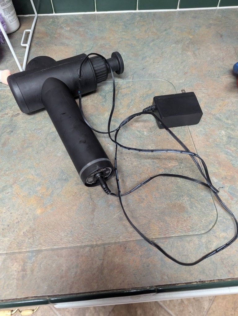 portable cordless massage gun, used for deep tissue massage and muscle recovery