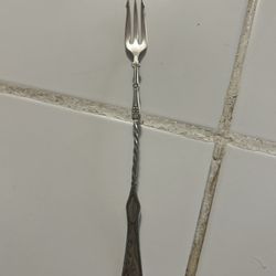 antique or vintage silver pickle fork, commonly featuring a long, twisted handle and three or four tines specifically designed for spearing pickles, o