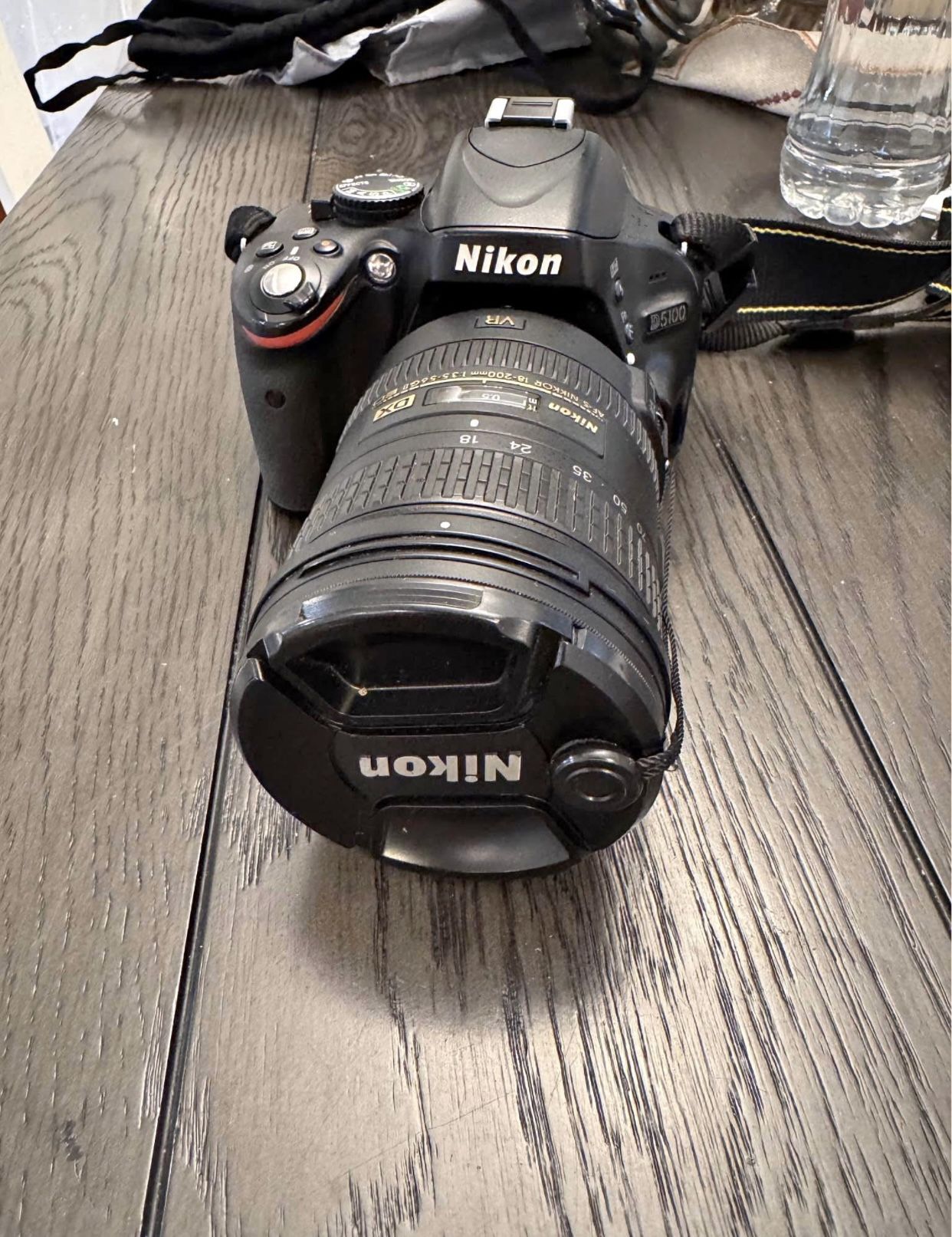 Nikon D5100 with 18-200mm lens, 18-55mm lens, battery x2, charger, and carry case with water cover