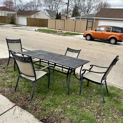 Large patio table 6x3 and 4 chairs, 1 of the chairs has some foam spray on it, but is still usable
