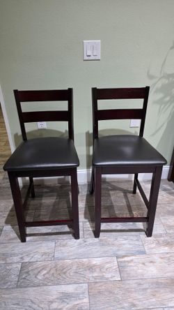 2 brown counter height chairs